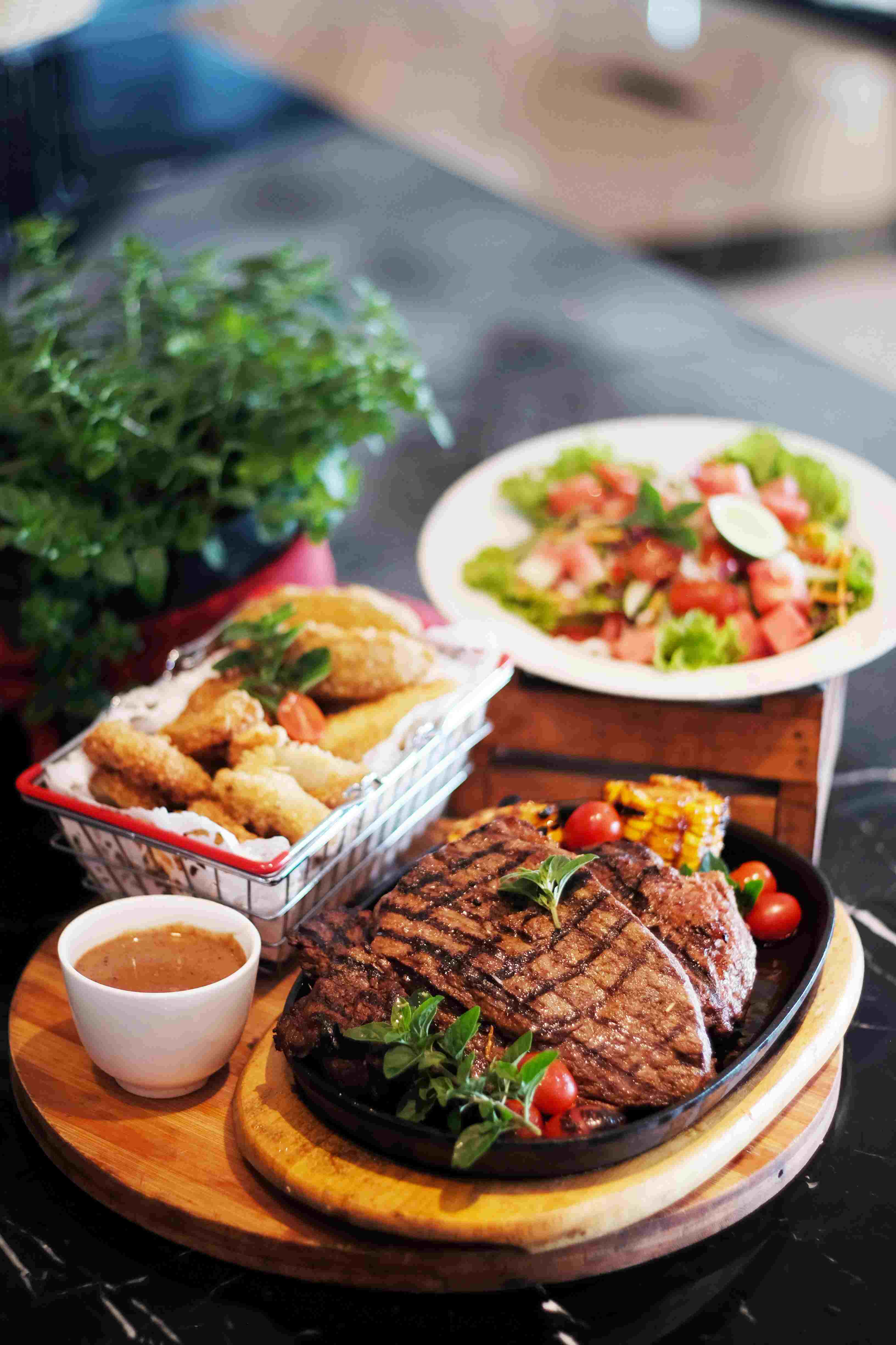 Steak on a plate with side dishes and sauce